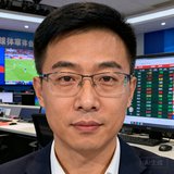 一位戴眼镜的中国男性体育记者正面头像，背景为新闻编辑室，他正在使用球探体育平台查阅赛事数据